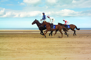 Horses racing on the beach