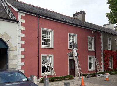 Photgraph of conservation works being undertaken on the exterior of a building by men on ladders