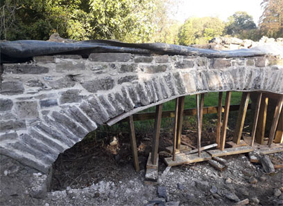 Photograph of a stone bridge undergoing conservation works