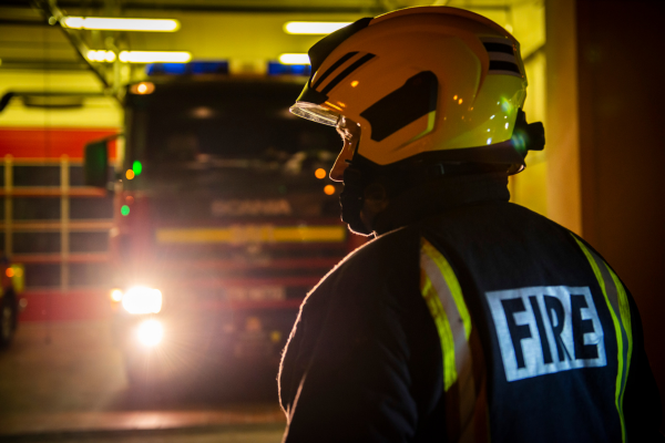 Firefighter standing in front of fire engine