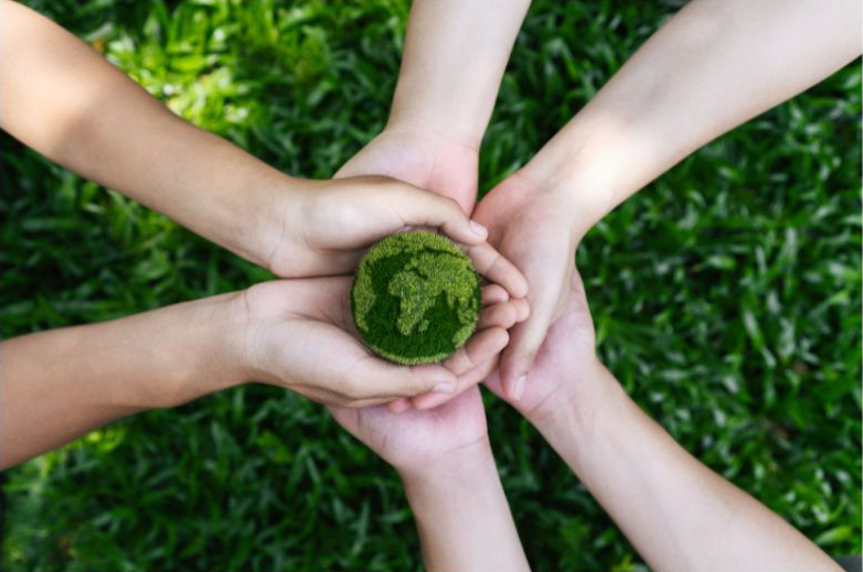 3 sets of hands cradling some mossy earth