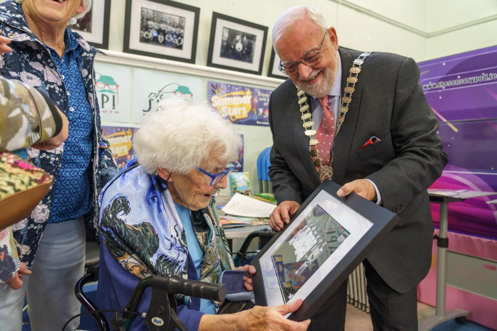 Ita Murray receiving a framed image from the Cathaoirleach