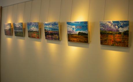 a row of paintings on the wall